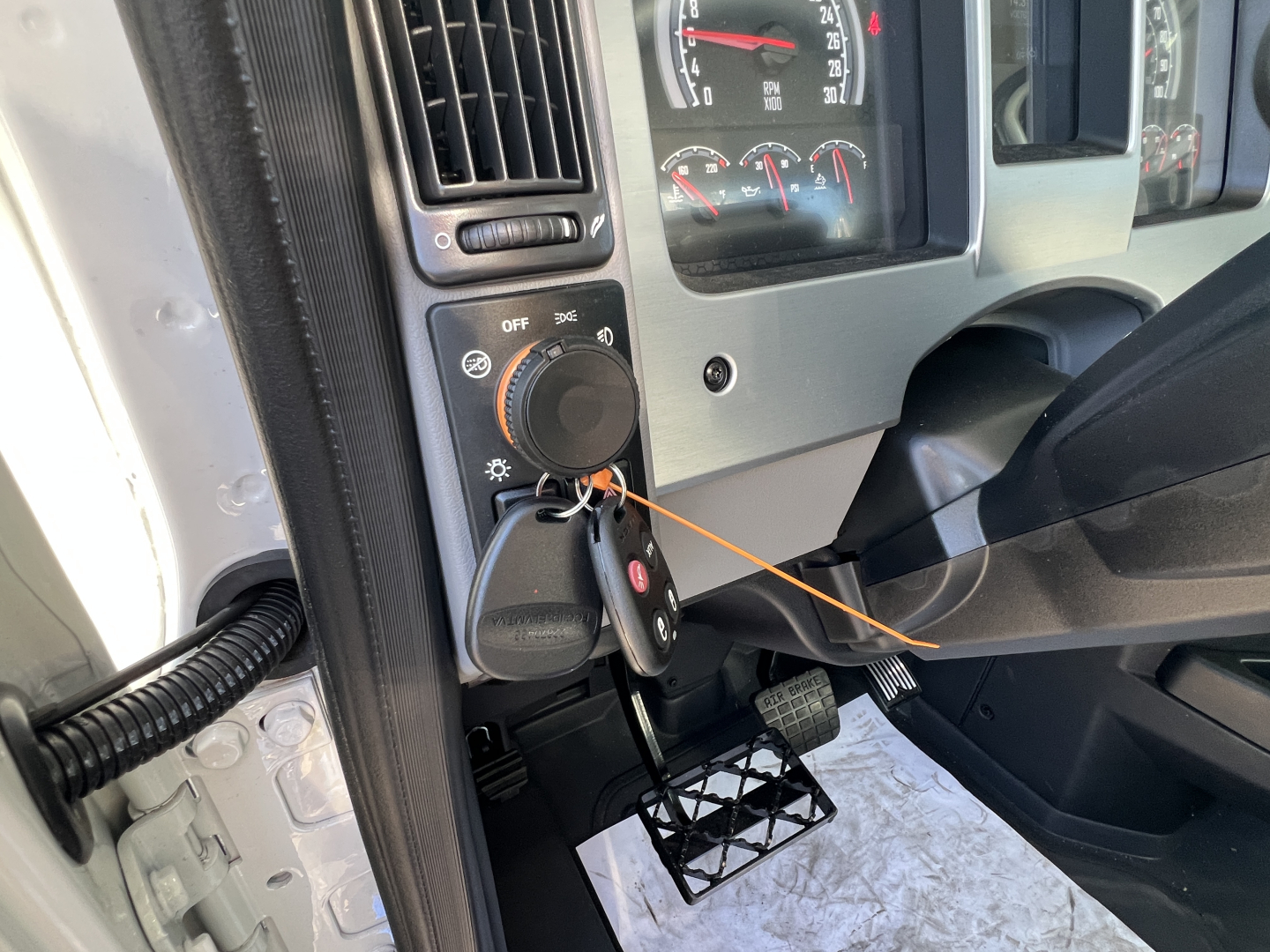 Dashboard view of a 2027 Mack GR84FT cab showing ignition switch with key, steering column, and instrument gauges