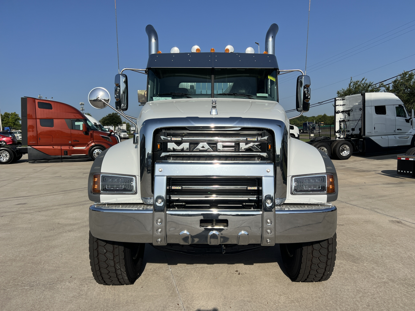 Front view of a 2027 Mack GR84FT conventional daycab truck showing large chrome grille with Mack logo, bumper guard, dual heavy-duty lights, and tall exhaust stacks.