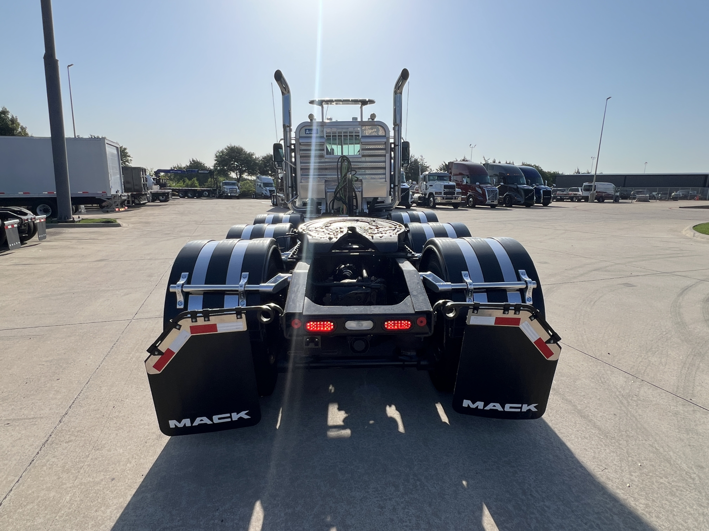 Rear view of a 2027 Mack GR84FT conventional daycab tractor showing dual rear axles and mudflaps with MACK branding.