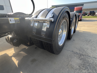 Truck rear axle and dual tires of a 2027 Mack GR84FT conventional daycab showing dual rear wheels and fenders.