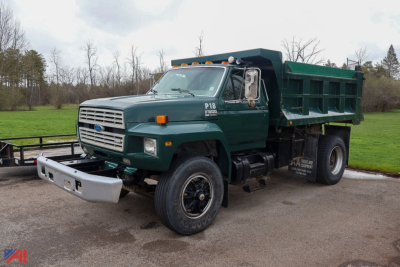 Ford F800 dump truck in green with front bumper, large dump bed, and dual rear wheels, side view.