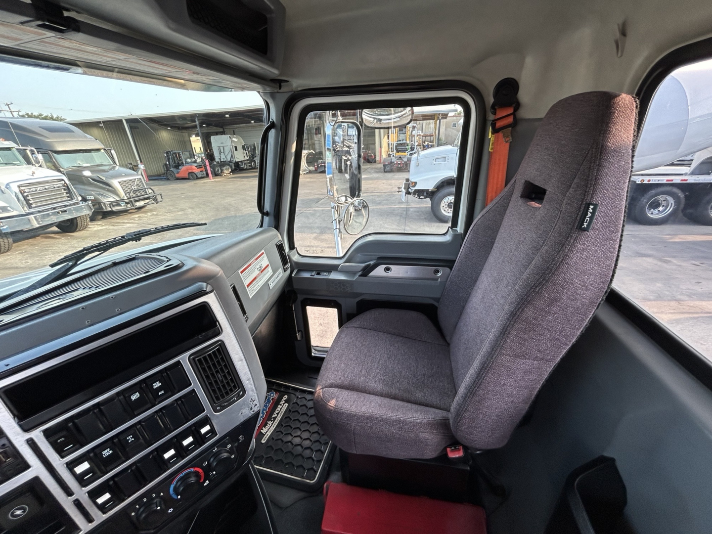 Truck cab interior showing driver seat and dashboard of a 2020 Mack GR64B mixer truck.