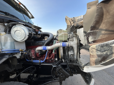 Image of a 2020 Mack GR64B mixer truck engine bay showing coolant reservoir, hoses, turbocharger, and exposed engine components.