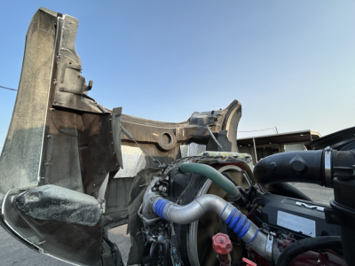 Truck engine bay and front chassis area of a 2020 Mack GR64B mixer showing hoses, radiator support, and engine components.