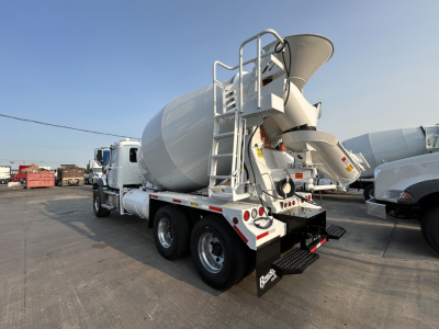 Mixer truck with cement mixer drum and ladder chassis in a yard showing rear and side view.