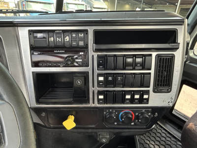 Dashboard of a 2020 Mack GR64B mixer showing gear selector, control switches, vents, and yellow power knob.