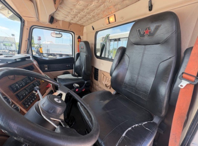 Cab interior of a 2020 Western Star 4700SF truck showing steering wheel, dashboard, driver seat with WV logo, and beige interior panels.