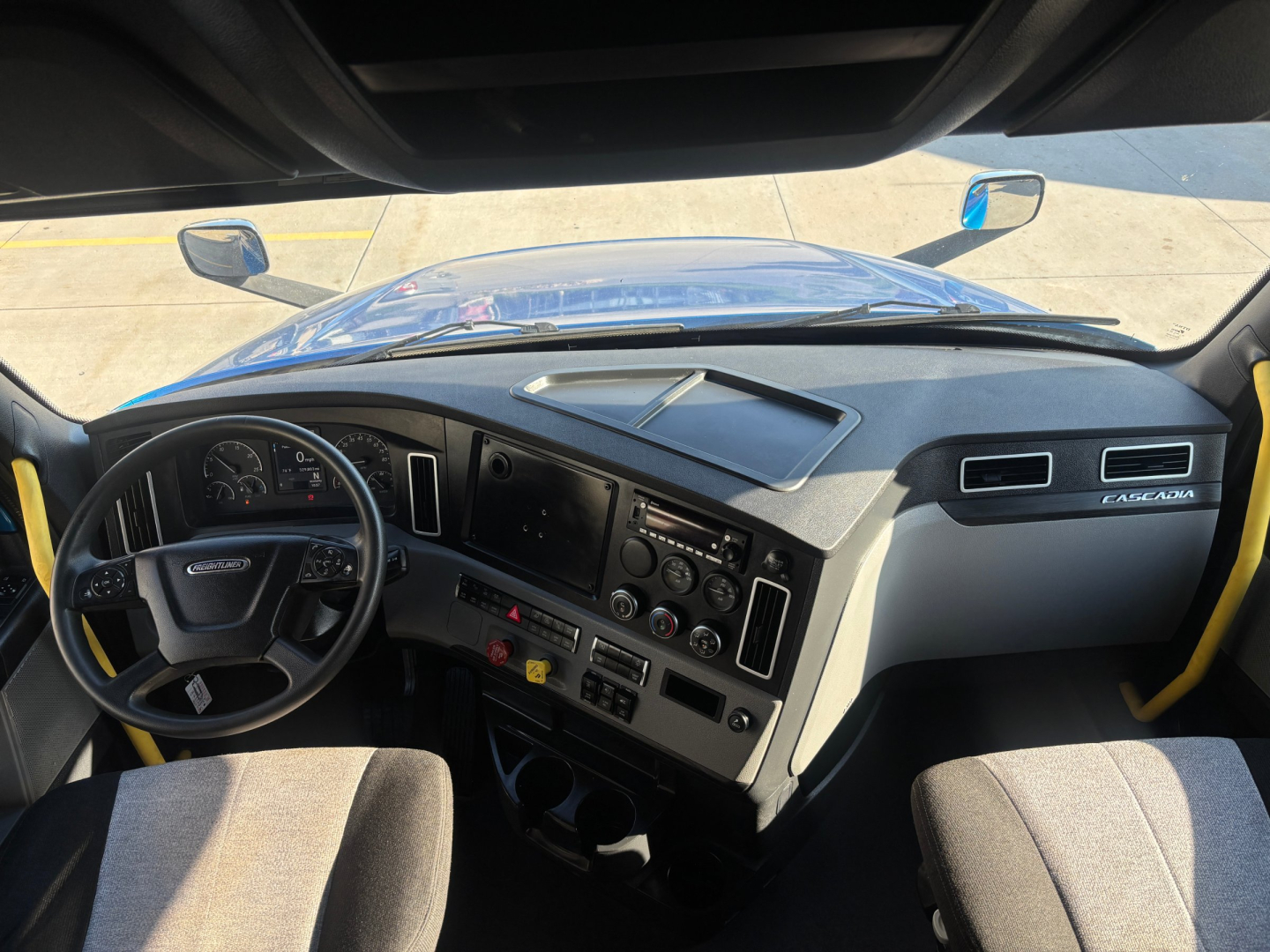 Cab interior of Freightliner PT126064ST truck showing steering wheel, dashboard, center console, and driver and passenger seats.