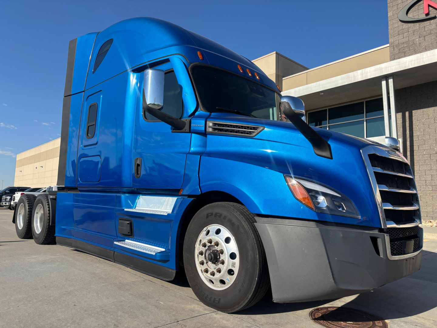 Blue Freightliner PT126064ST sleeper tractor truck side view showing cab with aerodynamic mirrors and large front grille.