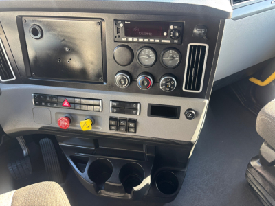 Dashboard of a Freightliner PT126064ST showing instrument cluster, blank panel, climate controls, and cup holders. Looks like a sleeper cab, standard dashboard panels visible.