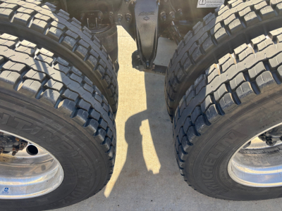 View of dual rear axles and tires on a Freightliner truck chassis, with twin wheels and heavy-duty rims visible.