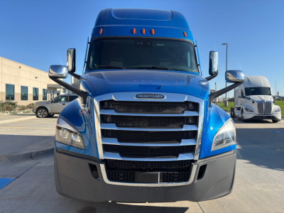 Front view of a blue Freightliner PT126064ST conventional sleeper truck showing chrome grille, bumper, and large windshield.