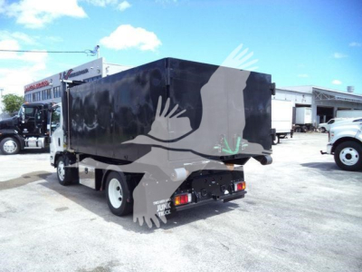 Isuzu NPR HD box truck with black cargo box viewed from rear-left; visible bumper and rear lights.