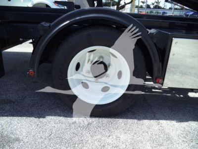 Isuzu NPR HD truck rear wheel and fender with spare wheel well visible; no legible text on signs