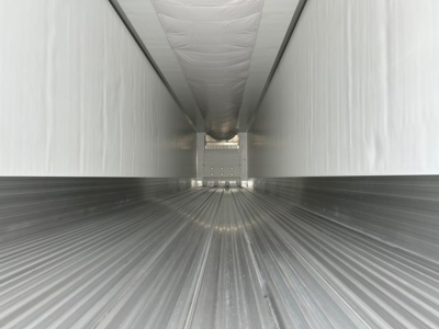 Trailer interior of a new Utility 3000R reefer showing ribbed floor and sidewalls with rear bulkhead.