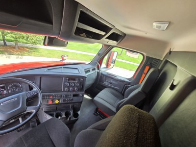 Truck cab interior from driver seat perspective showing dashboard, steering wheel, and glove compartments. Includes vents, gauges, and control panel details.