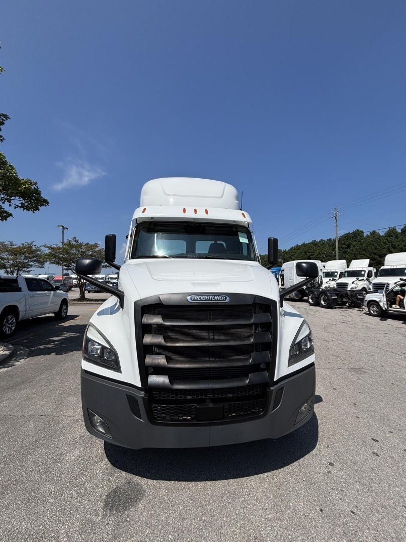 Front view of a white Freightliner Cascadia 126 day cab truck showing grille, headlights, and bumper.