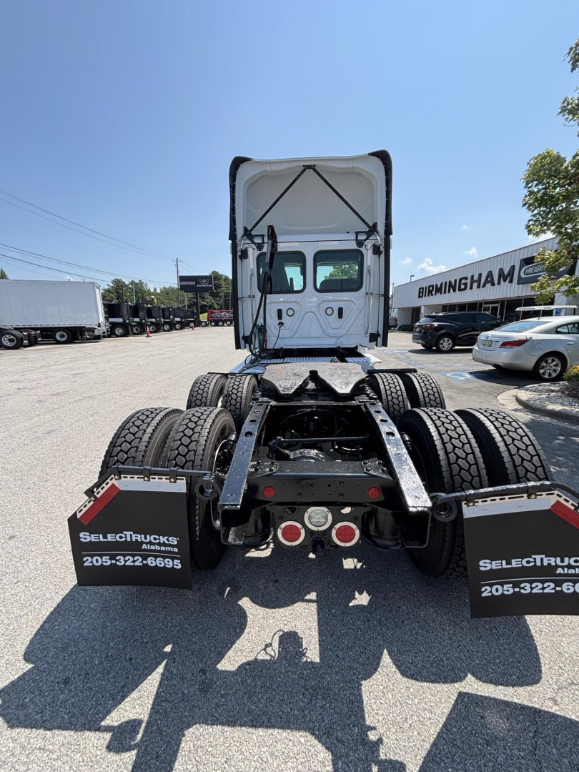 Freightliner Cascadia 126 tractor rear view showing dual rear axles and mudflaps with SelectTrucks contact numbers.
