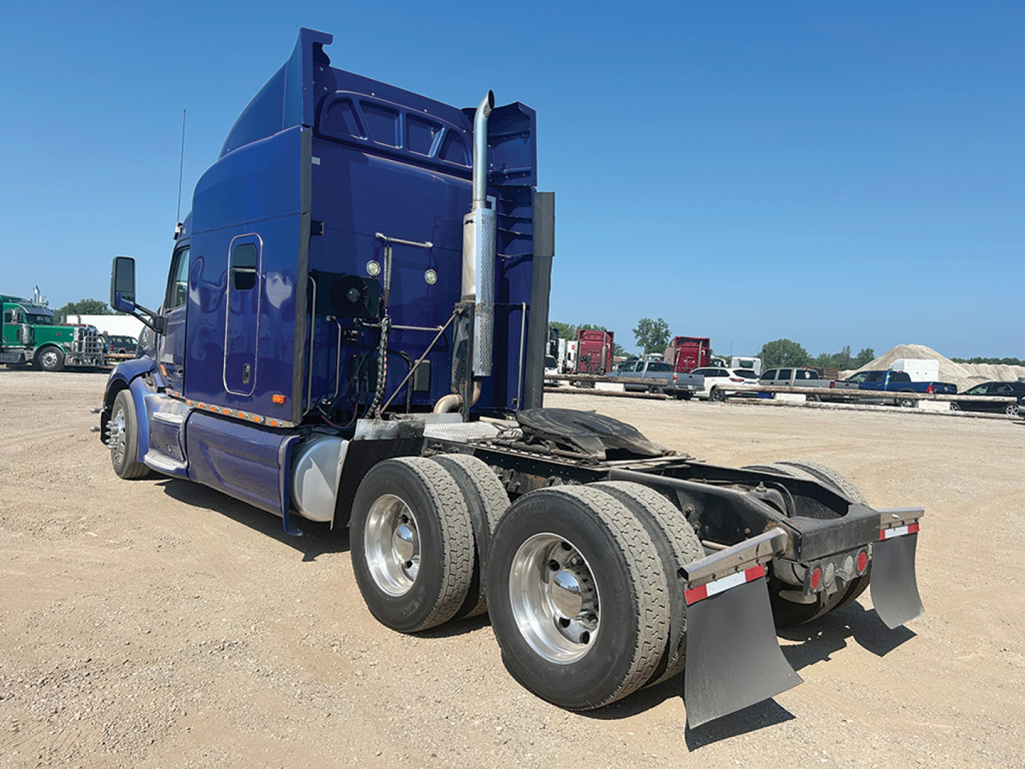 Peterbilt 579 UltraCab tractor rear view showing dual rear axles and chassis with mud flaps.