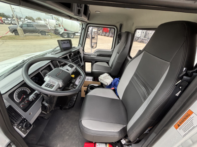 Cab interior of 2026 Mack MD7 truck showing steering wheel, dashboard, and driver's seat with center console.