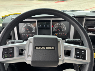 Mack MD7 steering wheel and dashboard center showing instrument cluster and control buttons