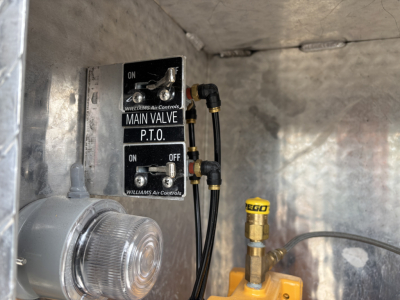 Main valve P.T.O. and Williams Air Controls switches in a metal truck compartment along with a yellow FEGO fitting and a round light lens.