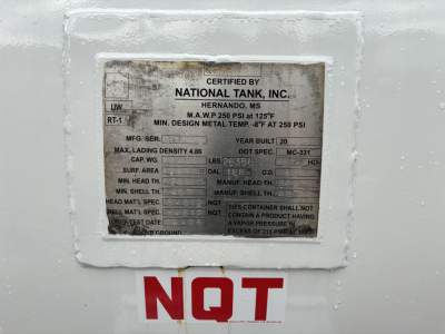 Certified by National Tank, Inc. plate on a white surface with NQT marking in red letters below and a vehicle VIN plate visible.