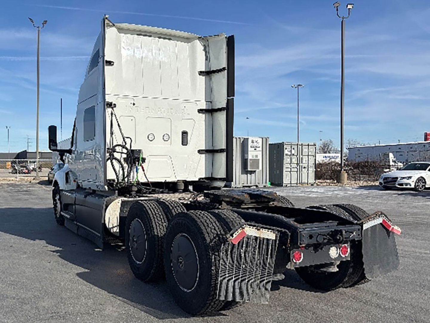 Truck cab and rear chassis of a 2023 International LT625 tractor seen from behind, with fifth wheel and dual rear axles visible