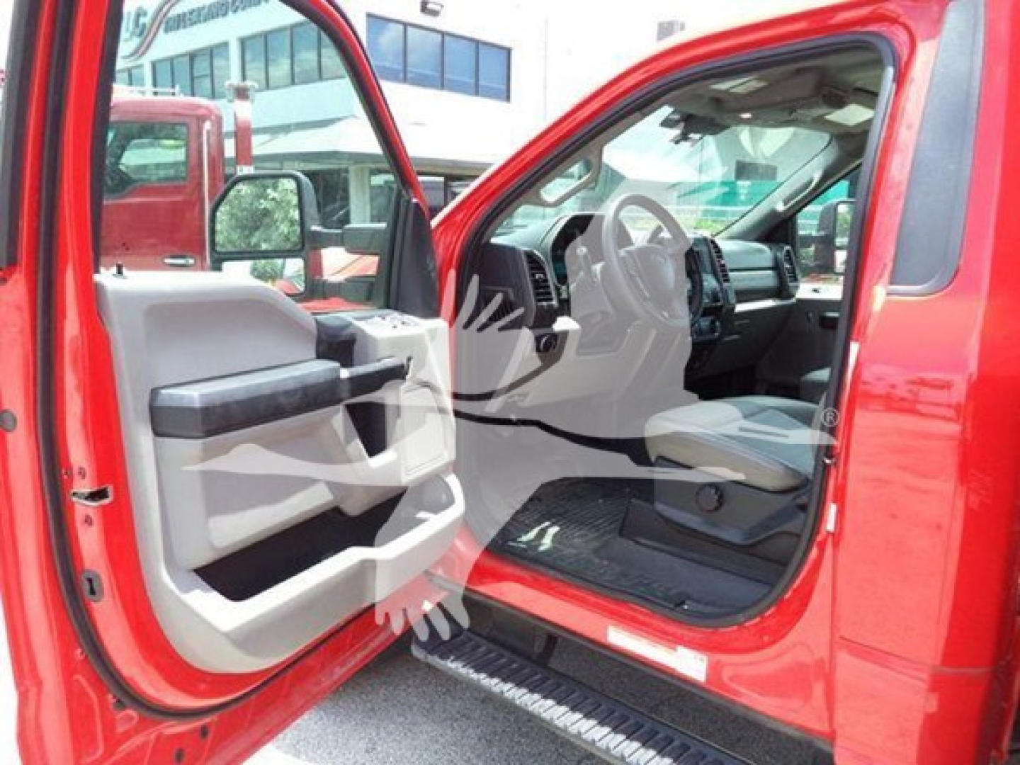 Ford F-550 cab interior with door open showing driver seat and dashboard, red exterior, front entry view.