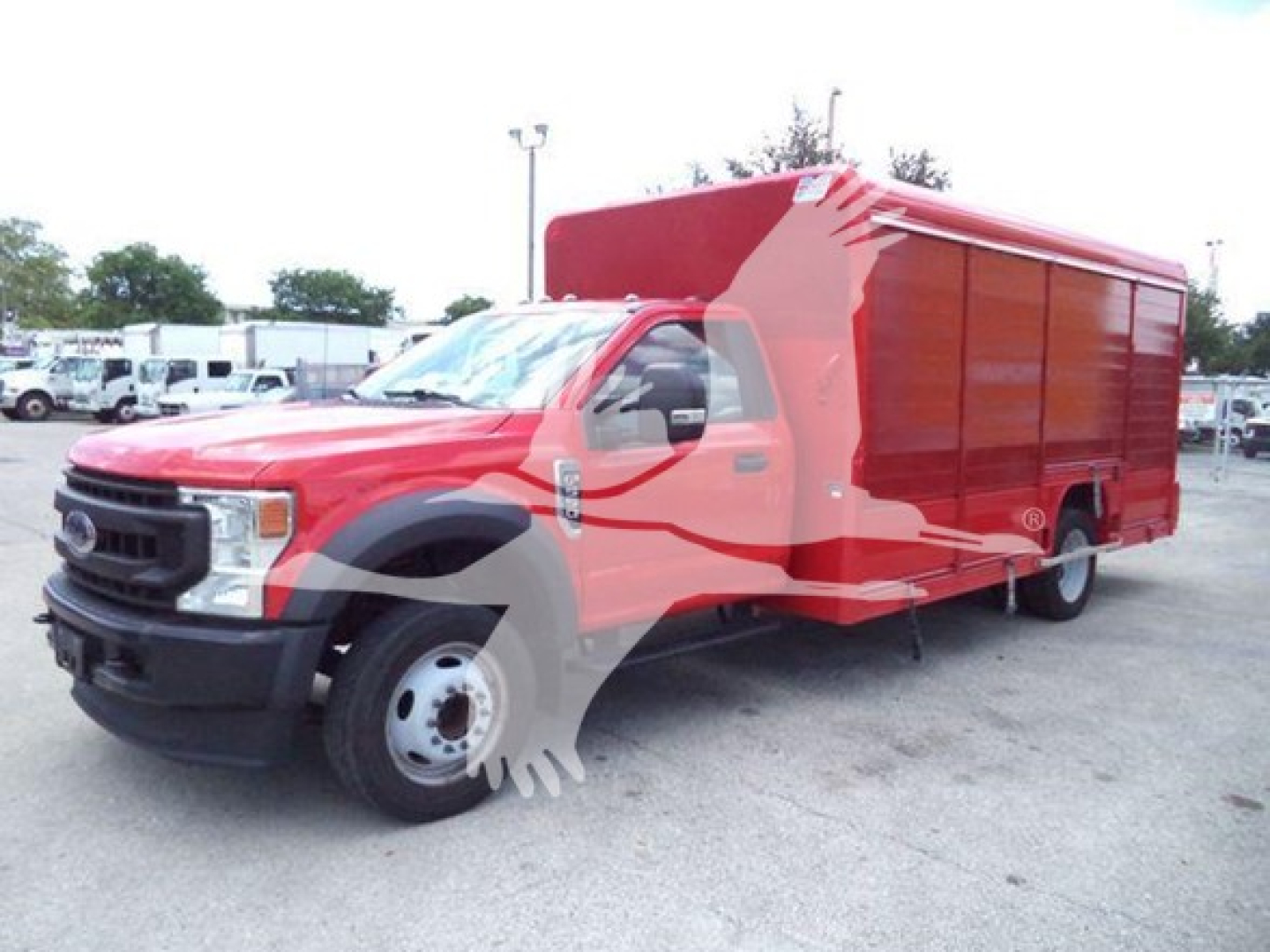 Ford F-550 service truck with red utility box on a dealership lot. Text visible includes front grille Ford emblem and no other legible labels.