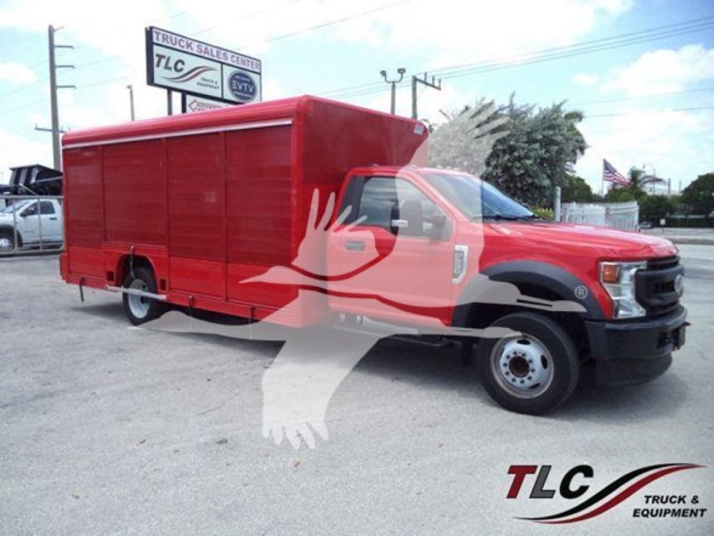 Ford F-550 service truck in red cargo body with taco logos and TLC Truck Sales Center sign in background.