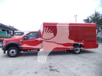 Ford F-550 truck in-service showing red beverage delivery body with white graphic art, side view