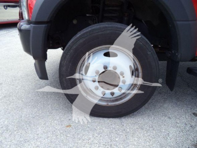Ground-view of Ford F-550 front wheel and tire in vehicle bay