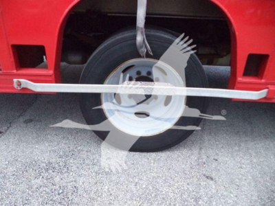 Ford F-550 wheel and bead area with black tire, red truck body, and silver side rail.