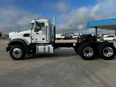 Mack GR64F dump truck side view showing cab and chassis with 6x4 rear dual axles and fuel tank.