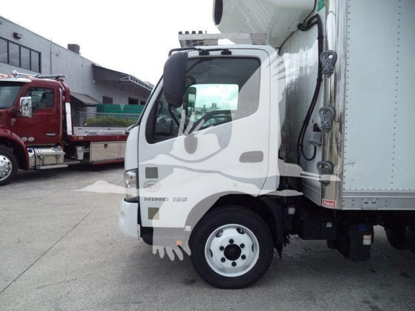 2019 Hino 195 refrigerated box truck cab-side view showing front wheel and cargo area.