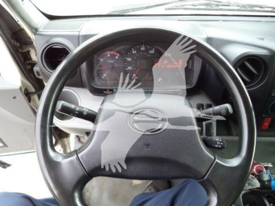 Steering wheel and dashboard view of a 2019 Hino 195 refrigerated truck showing steering wheel and instrument cluster.