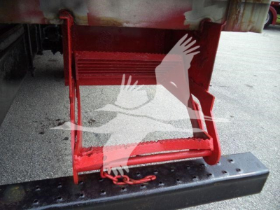 Rear undercarriage of a refrigerated truck with red steps and a black bumper, visible text not legible.