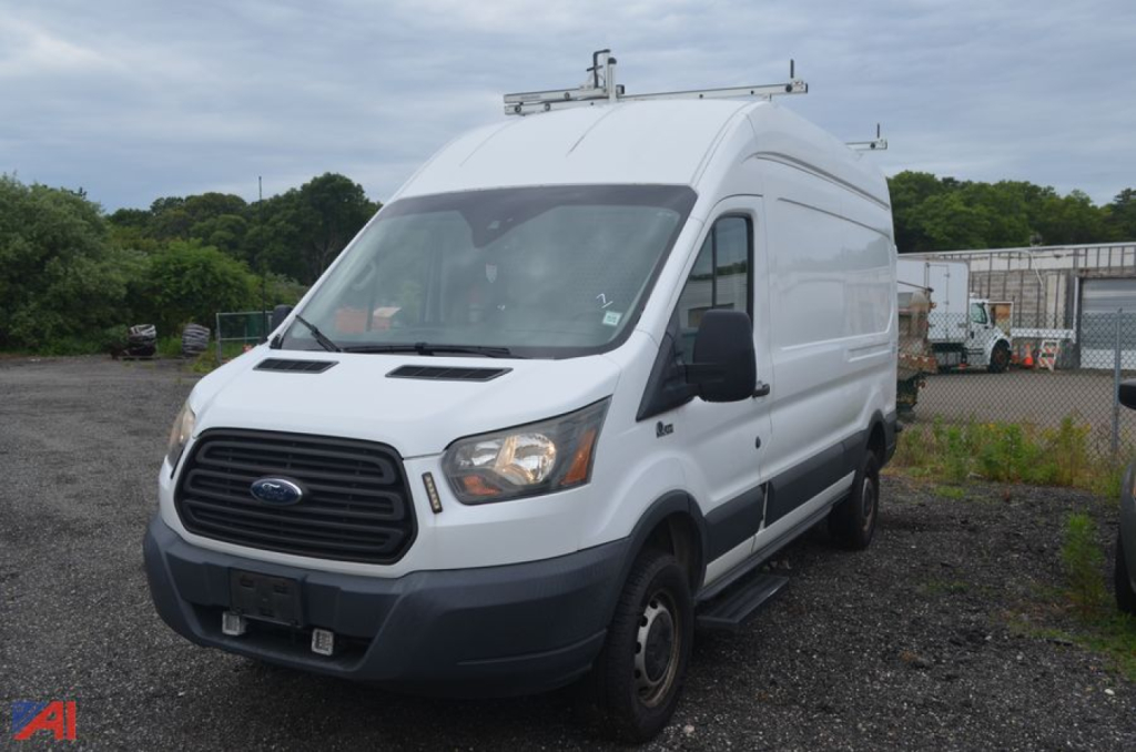 Ford Transit 2016 cargo van viewed from passenger side with roof rack and ladder rails.