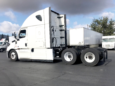 Freightliner Cascadia126 sleeper cab truck with white exterior, side view showing fuel tanks and rear wheels.