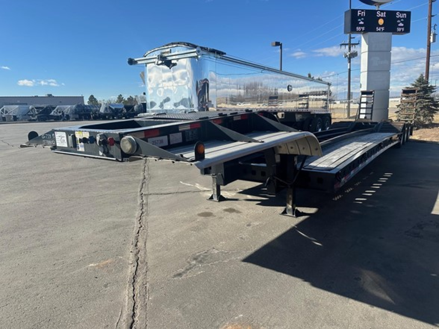 Kalyn Siebert Beaver Tail trailer in service position showing tandem axles and hydraulic ramps.