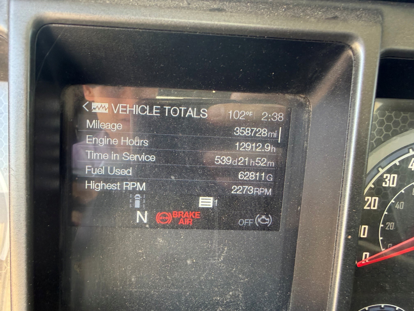 Mack Anthem instrument cluster displaying vehicle totals: Mileage 358,728 mi, Engine Hours 12,912.9 h, Time in Service 53d 21h 52m, Fuel Used 62,811 gal, Highest RPM 2,273 RPM, gear N and brake indicator visible.