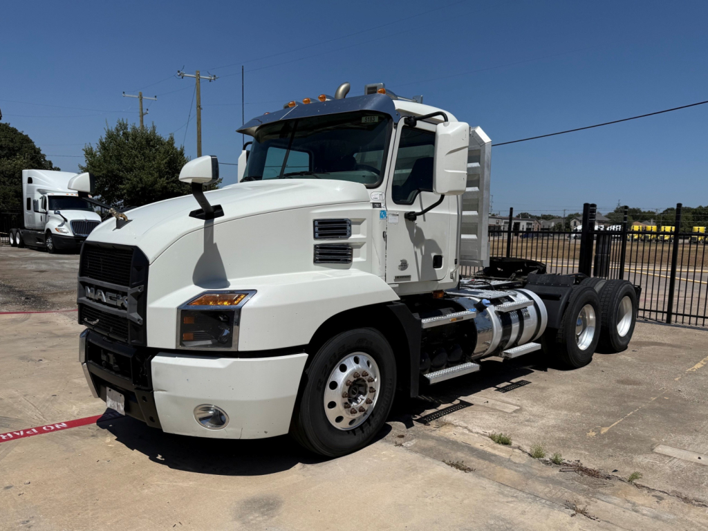 Mack Anthem daycab truck in white side view showing cab, fuel tanks, and dual rear axles.