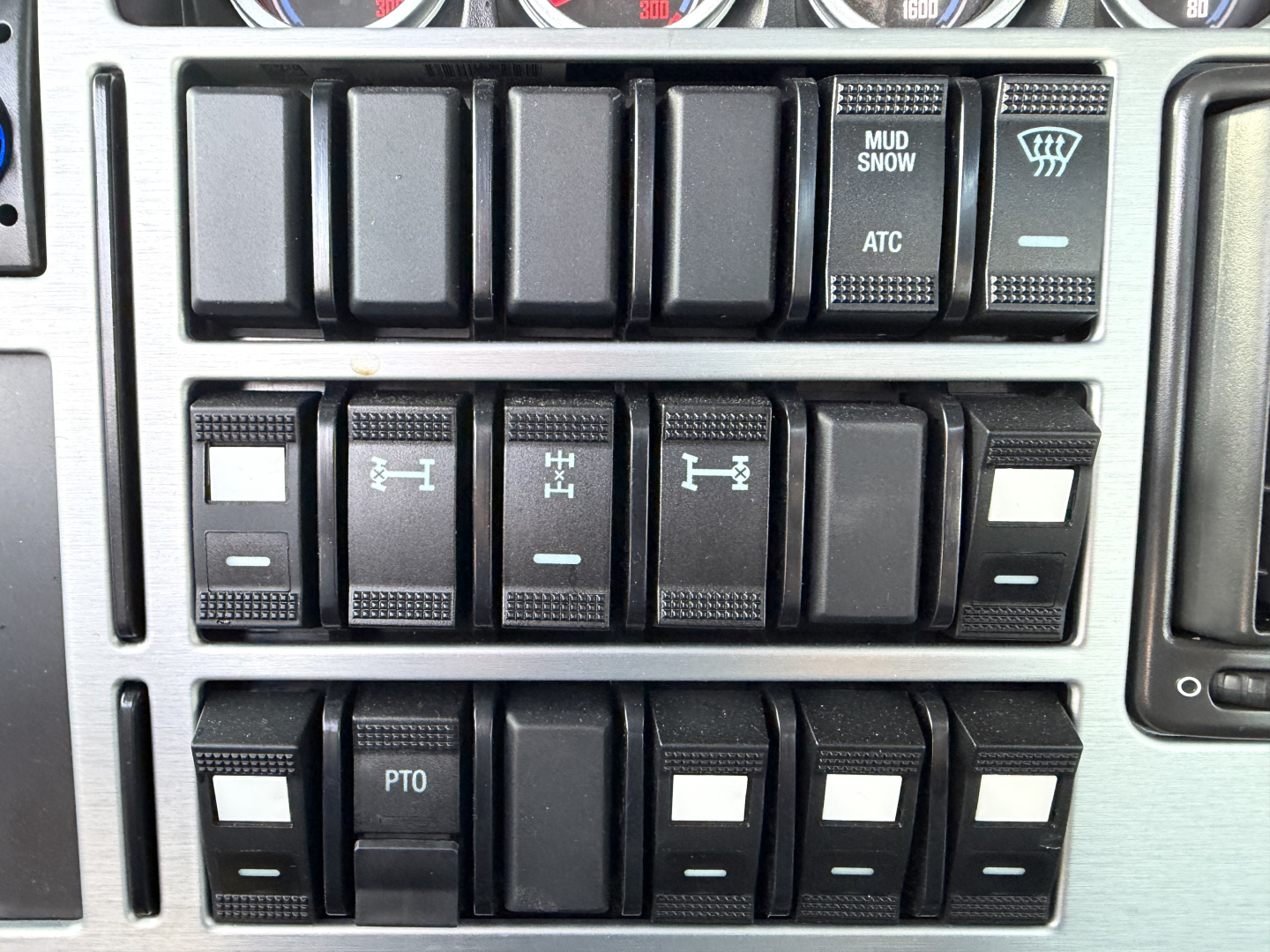 Mack GR64B dashboard switches row showing various toggles and labels like MUD SNOW ATC and PTO in a truck cab