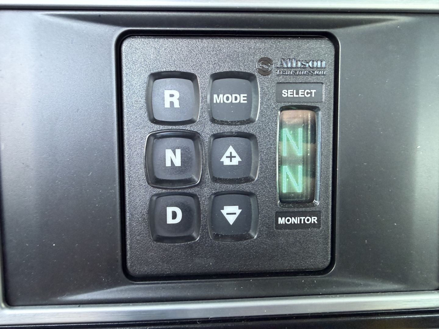 Mack GR64B cab interior showing gear selector panel with R MODE N + D and green N indicators, monitor button, and select label.