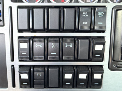 Mack GR64B dashboard switches row showing various toggles and labels like MUD SNOW ATC and PTO in a truck cab