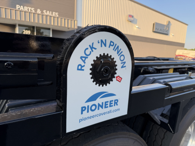 Rear view of a 2027 Mack GR64B roll-off truck showing a Rack 'N Pinion Pioneer cover with gear image and text.