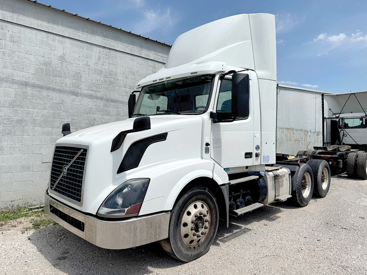 Volvo VNL 300 sleeper cab truck in white, front-left view with large fuel tanks and dual rear axles.