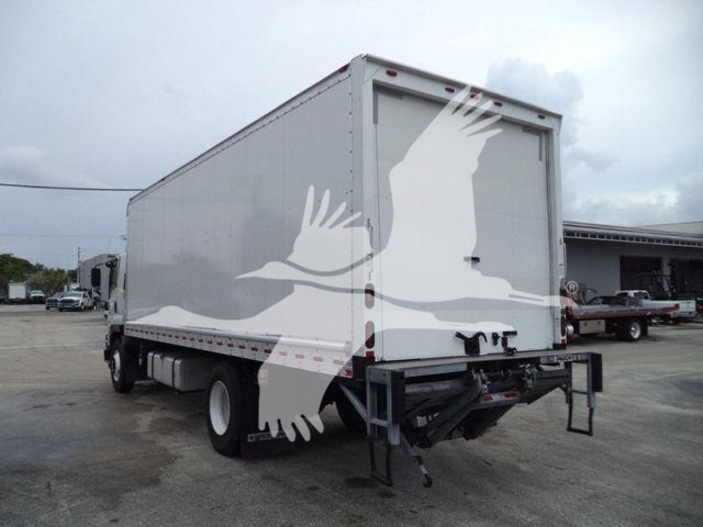 Isuzu box truck 2018 model shown from rear-left; cargo box with white paint, visible rear doors, undercarriage, and rear bumper/step.