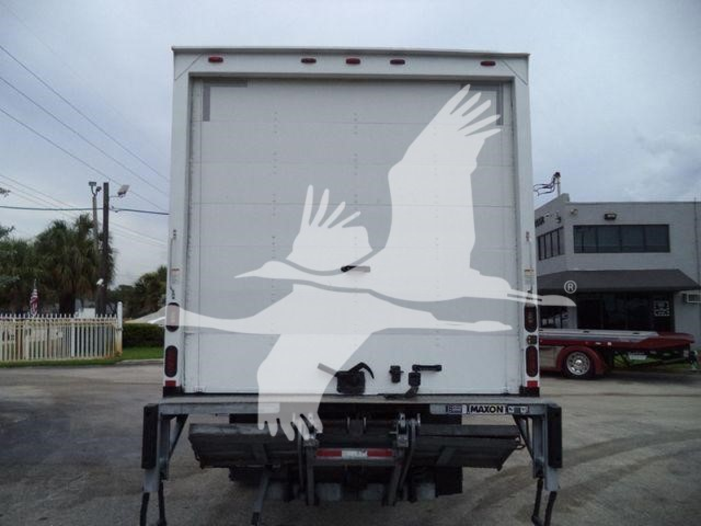 Back of a box truck with a white graphic of two birds in flight on the rear doors; license plate area and hitch visible.